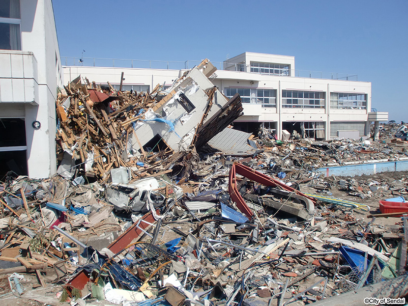 画像：津波で中野小学校の校舎の高さまで積み上げられたがれき