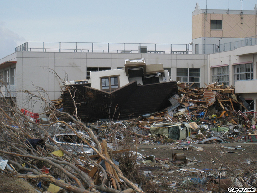 画像：津波で流出した家屋が中野小学校の校舎にぶつかり止る