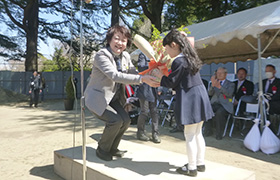 市長が代表の新入学小学生に記念樹を贈呈する様子