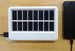 写真：スマートフォンの充電もできる小型太陽光発電機器