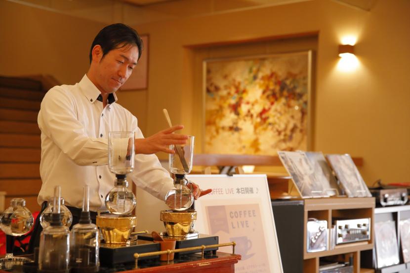 コーヒーを提供するスタッフの写真