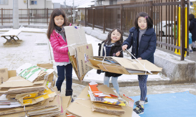 写真：「大きな段ボールも運べるよ」と笑顔を見せる子どもたち