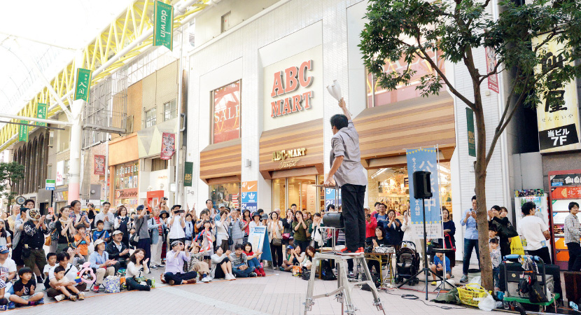 写真：道路の占用基準の緩和を活用して、市中心部商店街の歩道で大道芸のパフォーマンスを実施（平成28年10月）