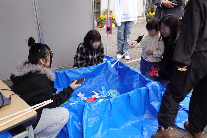 魚つり遊びブースを楽しむ親子連れ