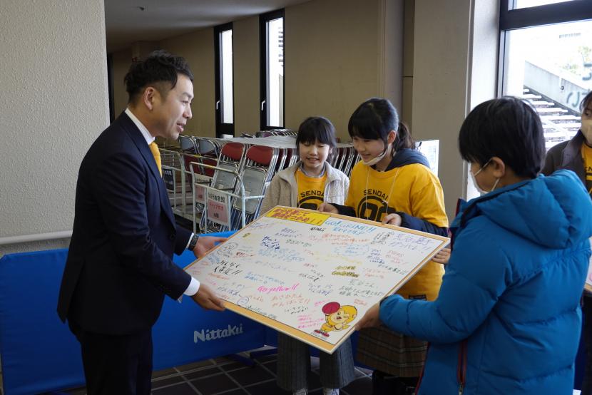 集まったメッセージを仙台エイティナイナーズの志村社長に渡している様子